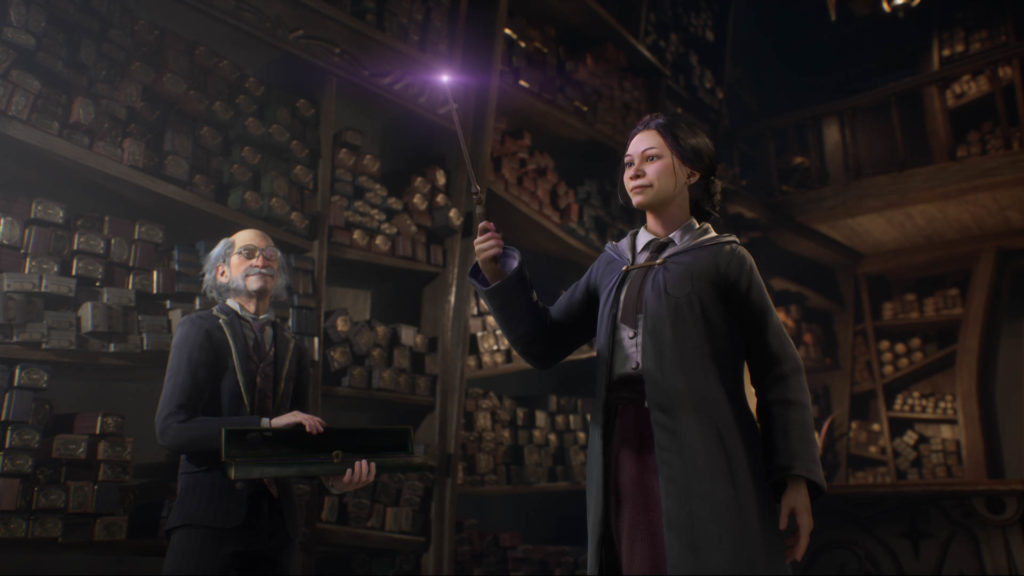 Une jeune sorcière tient une baguette magique dans sa main, devant tout un mur de baguettes magiques.