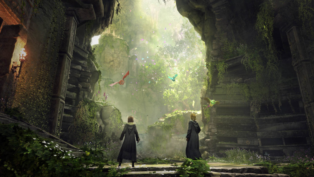 Deux jeunes sorcières du jeu vidéo Hogwarts Legacy font face à deux créatures volantes dans un environnement en ruines mais baigné d'une douce lumière.
